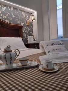 a bedroom with a bed with a tea set on it at O Pescador in Noya