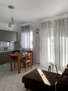 a kitchen and a living room with a table and a couch at Isolde Apartment in Kallithea Halkidikis