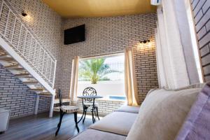 a room with a bed and a table and a window at Къщата с рибките in Sinemorets