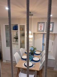 a dining room with a wooden table and white chairs at O Pescador in Noya +13 photos