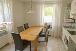 a kitchen with a wooden table and chairs at Casa Papa in Friedberg
