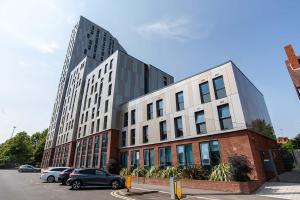 a large building with cars parked in a parking lot at Ensuite Single Room in Central Coventry in Coventry