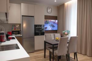 a kitchen and dining room with a table and chairs at MK Luxury Serviced Apartments # 4 in Chişinău