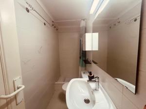 a white bathroom with a sink and a mirror at Maena San Maurici Lago in Empuriabrava +5 photos
