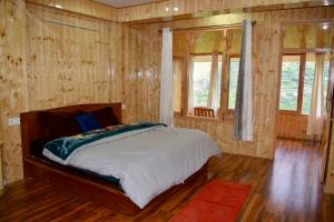 1 dormitorio con 1 cama con paredes y ventanas de madera en Keylong villa, en Kyelang 14 fotos más