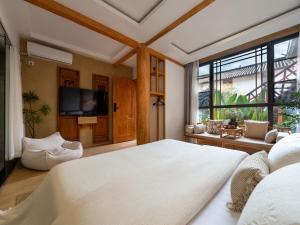 a bedroom with a large bed and a large window at Lijiang Lights Quiet Garden Desinger SerenityHaven Hotel B&B Gucheng Zhongyi Mufu Branch in Lijiang