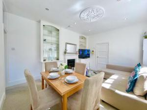 ロンドンにあるCentral Hammersmith 3-Bedroom Maisonette with Private Rooftop Terrace & FREE WiFiのテーブルとソファのあるダイニングルーム