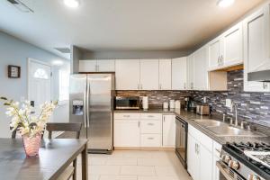 a kitchen with white cabinets and a stainless steel refrigerator at 7 Mito Louisville Jefferson Home in Jeffersonville