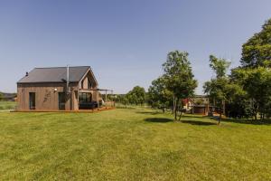 a wooden house in a field with a playground at Forrest Houses Bartosze in Bartosze