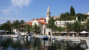 a group of boats in a body of water with a church at Apartment Vanda in Splitska