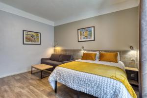 a bedroom with a bed and a couch at Hôtel Mistral Saint Roch in Montpellier