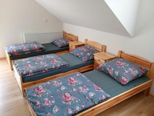 a group of three beds in a room at Domek pod Lipą in Nienaszów