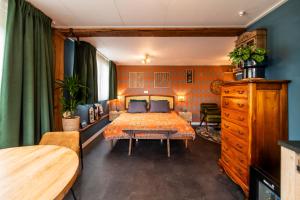 a bedroom with a bed and a table in it at B&B de Gouwe Tijd, suite "Gouden Ginkgo" in Noordgouwe