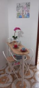 un tavolo con due sedie e un tavolo con fiori di Casa Monteserrato a Terrasini