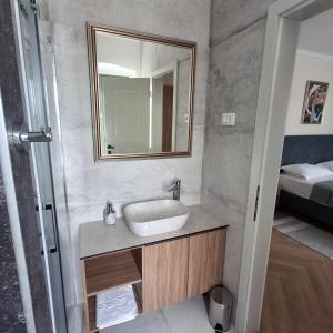 a bathroom with a sink and a mirror and a bed at Heritage Villa Francheza-Elegant Stone villa near the Beach, Pašman Island , Ugrinić in Ugrinići