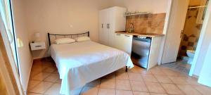 a small bedroom with a bed and a sink at Komi's Pink Paradise 3 in Chios