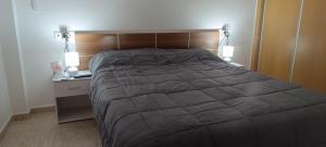 a bedroom with a large bed and two lamps at Apartalux San Pedro Mar in San Pedro del Pinatar
