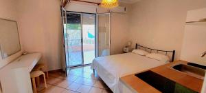 a bedroom with a bed and a sink and a window at Komi's Pink Paradise 3 in Chios