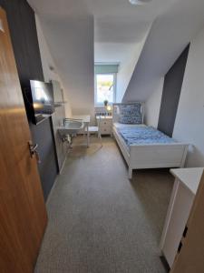 a attic room with a bed and a desk at Residencia del Pueblo II in Pirk