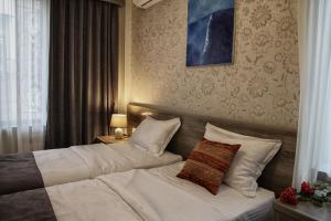 a hotel room with two beds with white pillows at Hotel Four Brothers in Tbilisi City