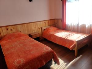 a bedroom with two twin beds and a window at cabañas walls 2 in Pucón