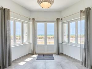 an empty living room with windows and a door at Holiday Home La Surprise by Interhome in Saint-Germain-sur-Ay