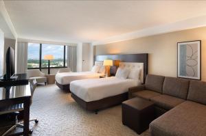 a hotel room with a bed and a couch at DoubleTree by Hilton Washington DC – Crystal City in Arlington