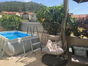 a hot tub and a chair next to a pool at Grace House in Belinho