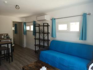 a living room with a blue couch and a table at L'Olivier in Saint-Mitre-les-Remparts