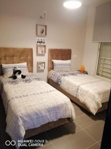 a bedroom with two beds with a cat sitting on them at Appartement Résidence balnéaire Dar Al bahr in Sidi Rahal +8 photos