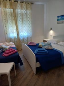 a bedroom with two beds and a chair at Appartamento Chiara in Roseto degli Abruzzi