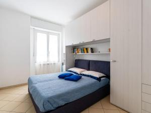 ein Schlafzimmer mit einem Bett mit zwei blauen Kissen in der Unterkunft Apartment Happiness by Interhome in Loano