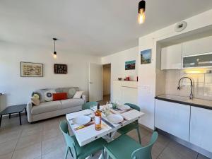 a kitchen and a living room with a table and chairs at Apartment Les Amarres de l'Aiguillon-4 by Interhome in Arcachon +23 photos