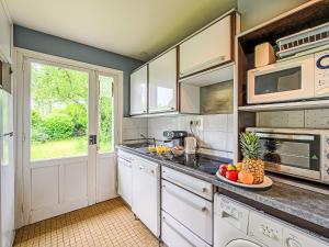 a kitchen with white cabinets and a plate of fruit on the counter at Holiday Home Arvor I-2 by Interhome in Carnac