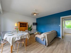 a dining room with a table and a blue wall at Holiday Home Arvor I-2 by Interhome in Carnac +18 photos