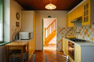 una cucina con mobili gialli e un tavolo con sedie di Eko Homestead Luka - Escape Room, Archery, BBQ, Rafting and more - a Vrh pri Fari