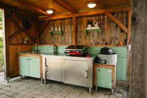 una cucina all'aperto con armadi verdi e piano cottura di Eko Homestead Luka - Escape Room, Archery, BBQ, Rafting and more - a Vrh pri Fari