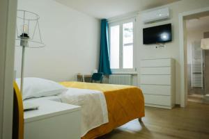 a bedroom with a bed with a yellow blanket at Good Vibes apartment centro storico Reggio Emilia in Reggio Emilia