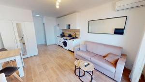 ein Wohnzimmer mit Sofa und Tisch in der Unterkunft Superbe studio climatisé entièrement rénové au 5ème et dernier étage sur le bord de Mer de Menton in Menton