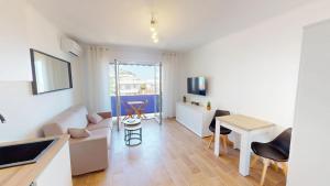 ein Wohnzimmer mit Sofa und Tisch in der Unterkunft Superbe studio climatisé entièrement rénové au 5ème et dernier étage sur le bord de Mer de Menton in Menton + 11 Fotos