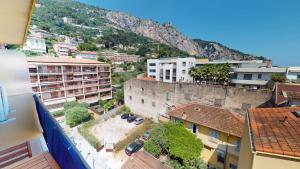 eine Luftansicht einer Stadt mit Gebäuden und einem Berg in der Unterkunft Superbe studio climatisé entièrement rénové au 5ème et dernier étage sur le bord de Mer de Menton in Menton