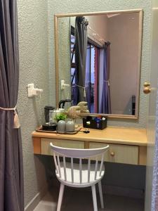 - une coiffeuse avec un miroir et une chaise blanche dans l'établissement Lilies & Leopards, à Mossel Bay