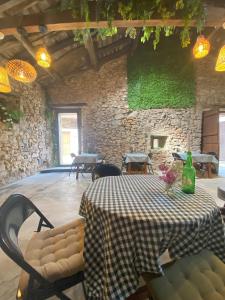 a room with a table and chairs and a stone wall at Casa Rural Casa Selmo in Carreno
