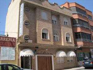a brick building on a street with a car parked in front at Hotel Miraflores in Alcobendas