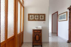 a hallway with a wooden door and a table at La Rotonda Fertilia apartment in Fertilia