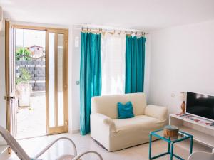 een woonkamer met een stoel en een televisie bij Apartment Wendy by Interhome in Santa Maria Navarrese