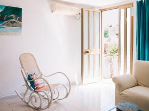 een schommelstoel in een woonkamer met een raam bij Apartment Wendy by Interhome in Santa Maria Navarrese