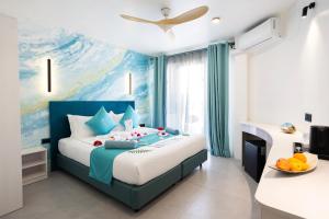 a bedroom with a blue and white bed and a desk at LOFT Maldives in Dhigurah