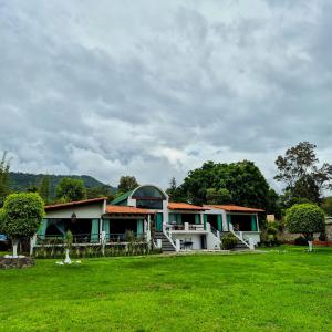 a house with a green lawn in front of it at Casa Valle Horus in Valle de Bravo