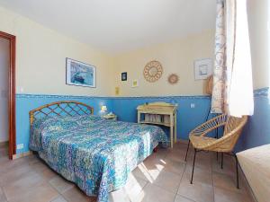 ein Schlafzimmer mit einem Bett und einem Stuhl in der Unterkunft Holiday Home La Perche by Interhome in Royan